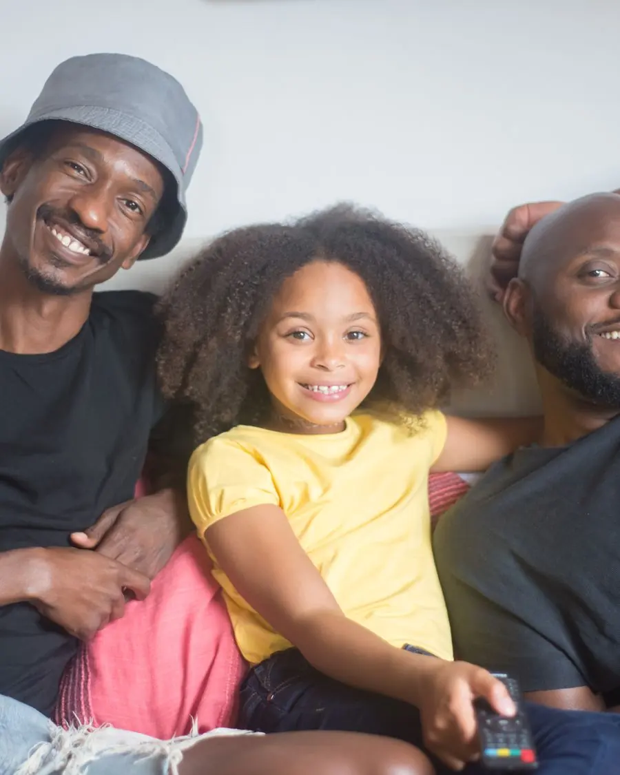 Família rindo junta no sofá de casa