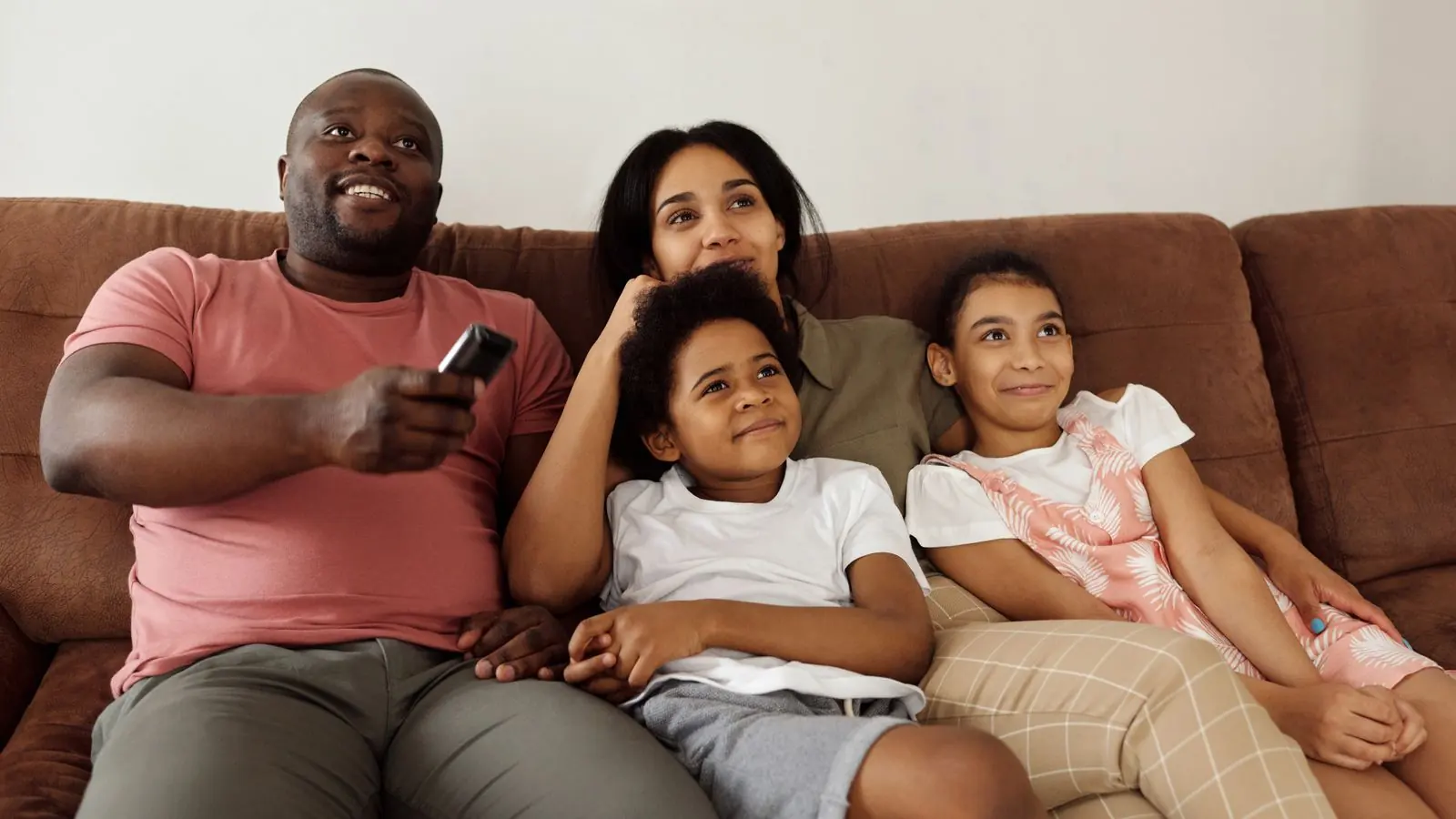 Família assistindo TV no sofá